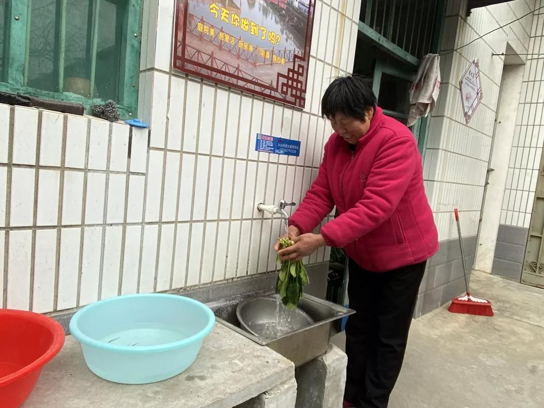 潘秋凤用自来水洗菜做饭.